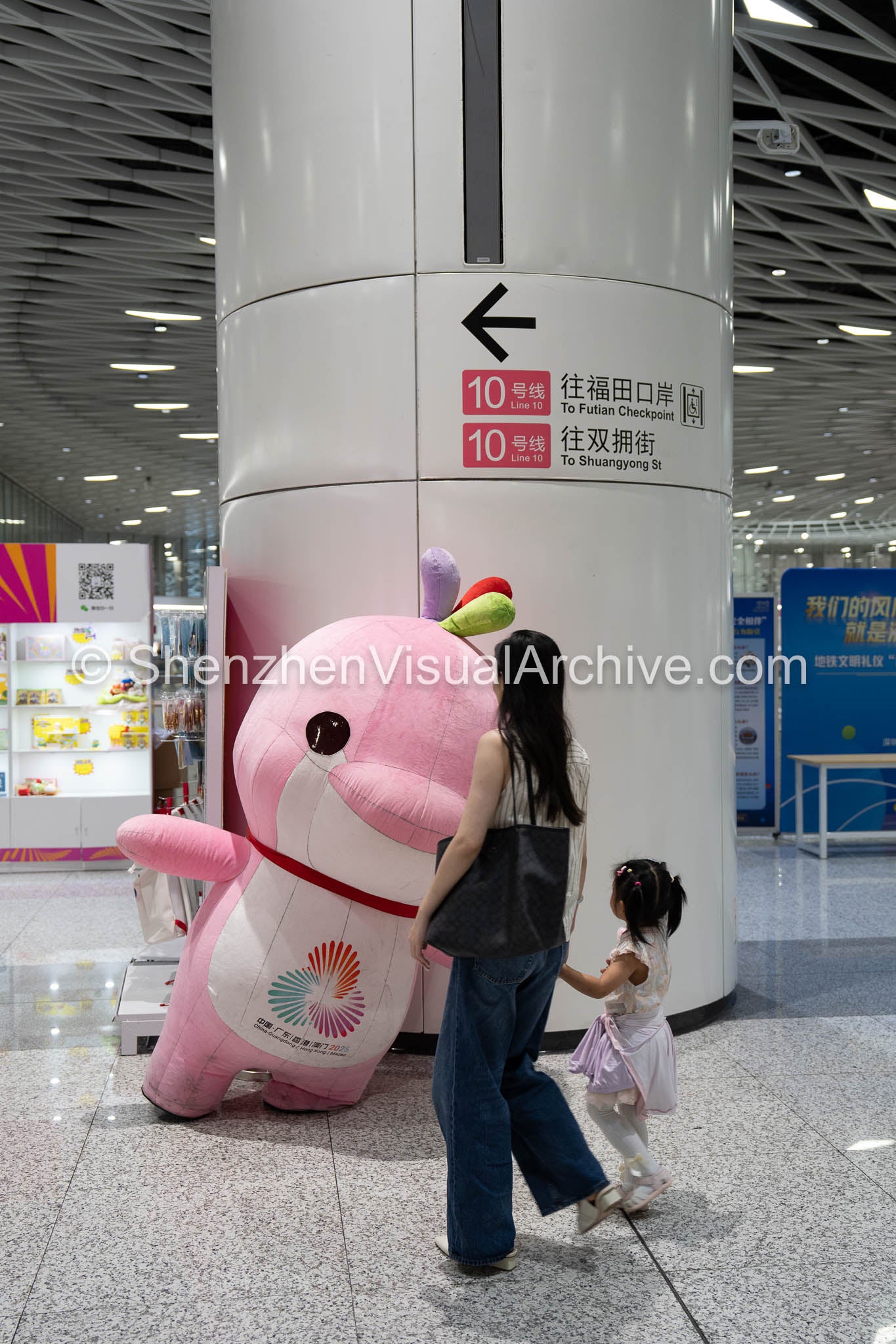 Family Moments: Mother and Daughter Greeting the National Games Mascot at Gangxia North (SVA-26-0086)