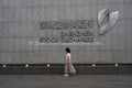 Financial District: Pedestrian Walking Past Shenzhen Stock Exchange Entrance Wall in Futian CBD (SVA-26-0181)