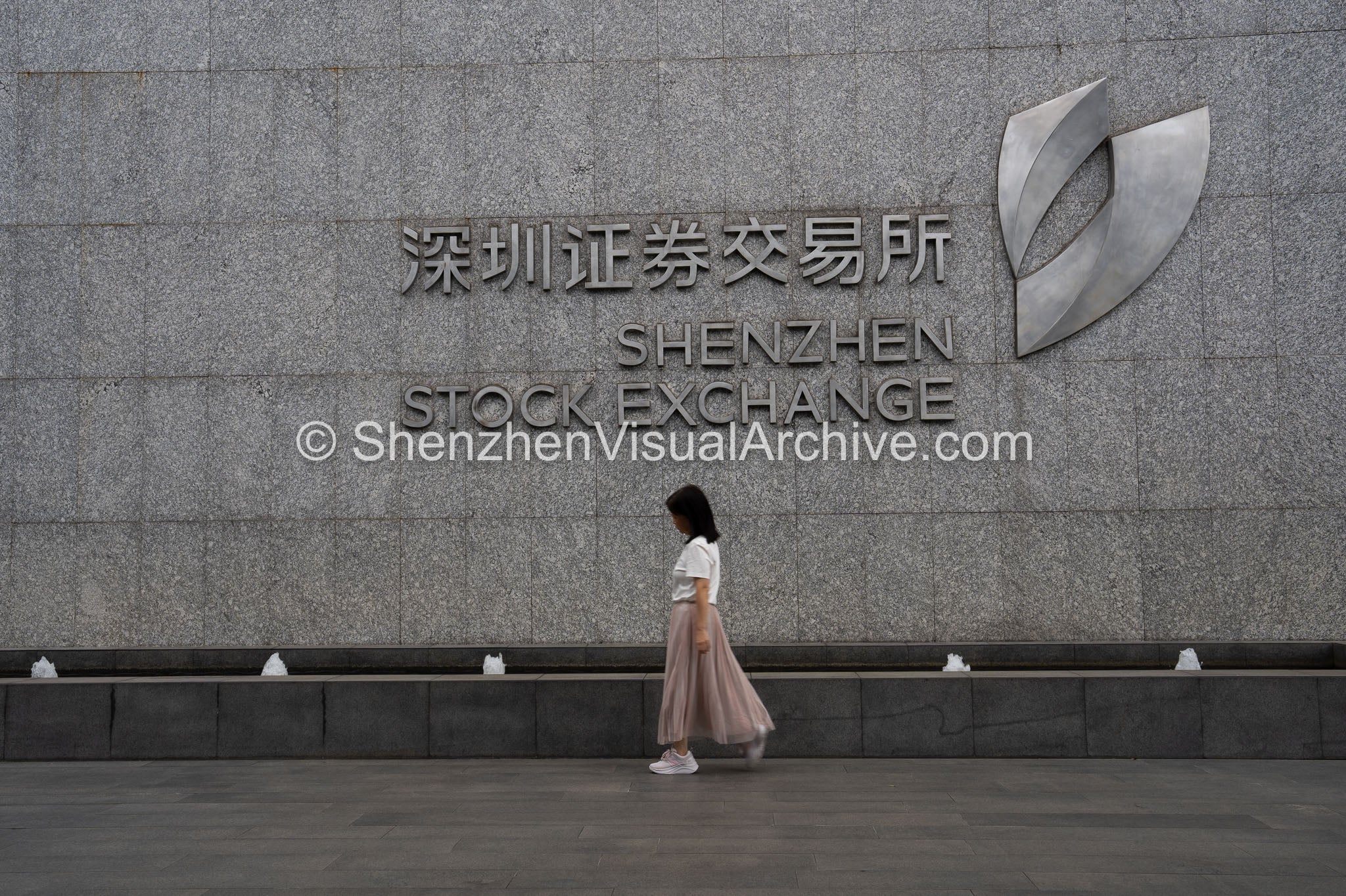 Financial District: Pedestrian Walking Past Shenzhen Stock Exchange Entrance Wall in Futian CBD (SVA-26-0181)