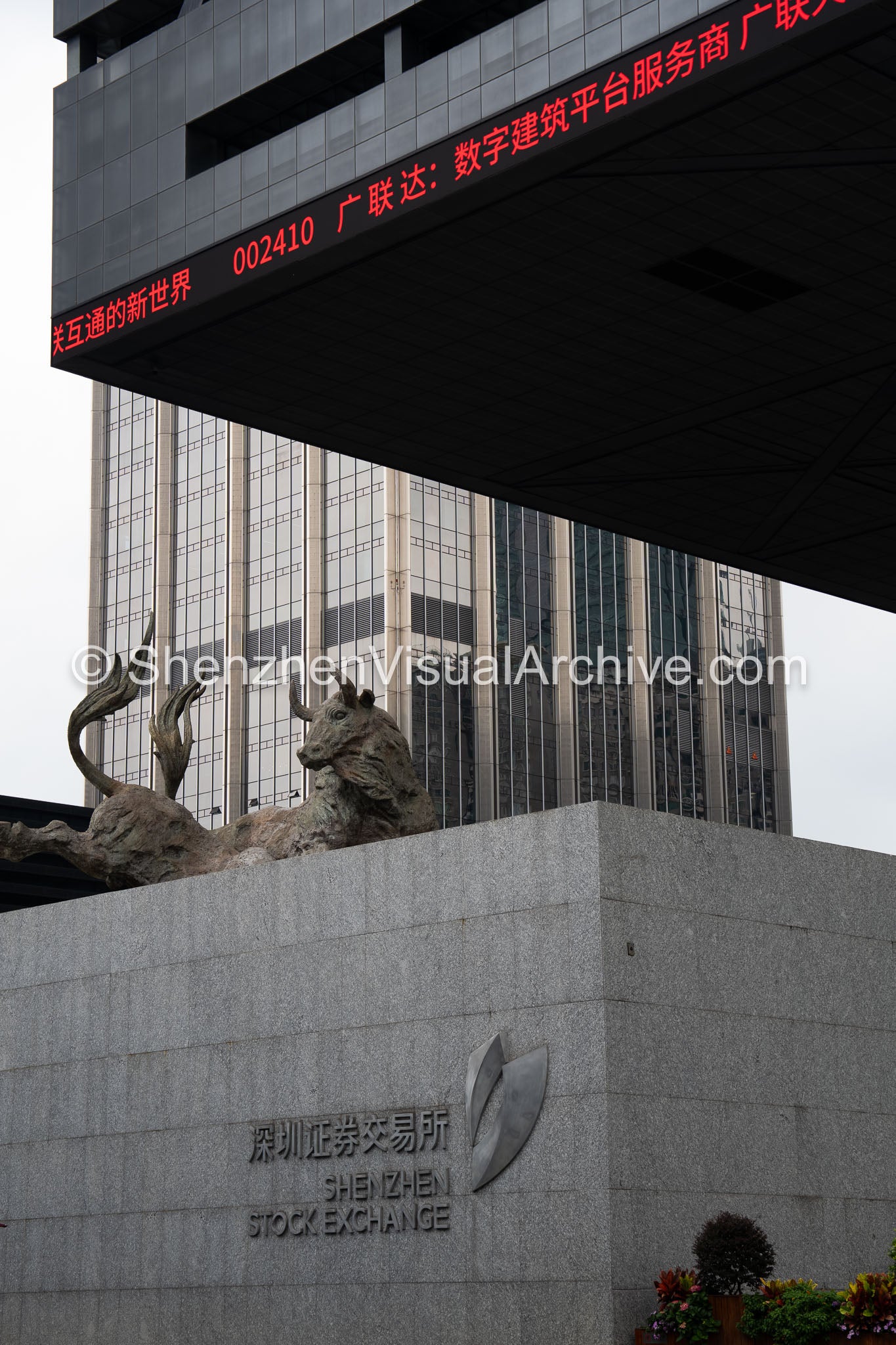 Financial District: Rising Bull Sculpture above Shenzhen Stock Exchange Identity Wall and Red Ticker (SVA-26-0192)